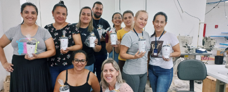 mulheres segurando, sorridentes, um presente entregue pela criativa têxtil em um dia especial